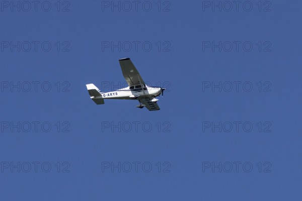 Cessna 172C Skyhawk aircraft flying in a blue sky, England, United Kingdom