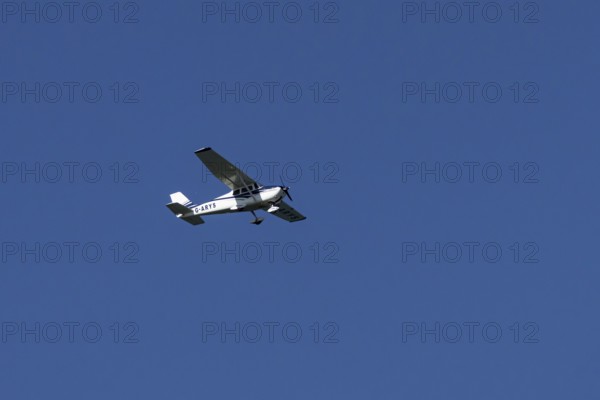 Cessna 172C Skyhawk light aircraft flying in a blue sky, England, United Kingdom