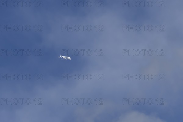 Airbus A330-743L Beluga XL cargo jet aircraft flying in a blue sky with white clouds, England,