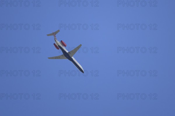 Embraer ERJ-145 jet passenger aircraft of Loganair airlines flying in a blue sky, England, United