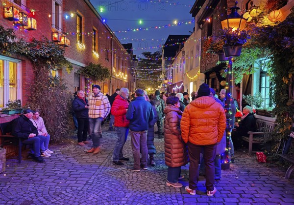 People in the Tiefstraße decorated for the Martin train in the evening, historic old town, Kempen,
