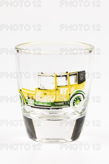 Shot glass with historic car motif, mainly in yellow