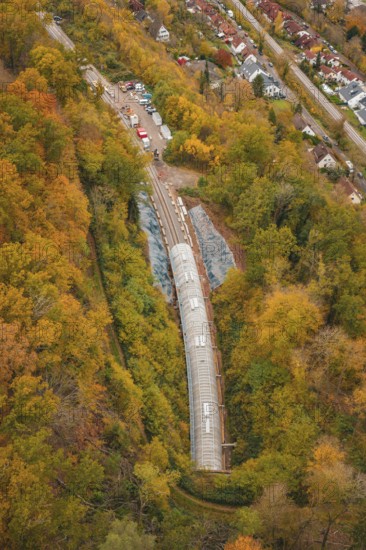 Autumn forest surrounds the construction site of a railway tunnel under construction,