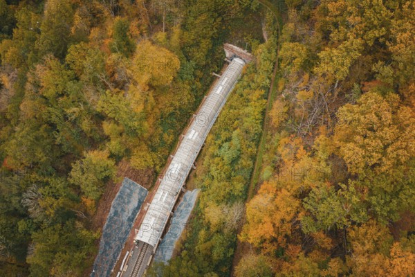 Aerial view of a train tunnel under construction surrounded by autumn trees, Hermann-Hesse-Bahn