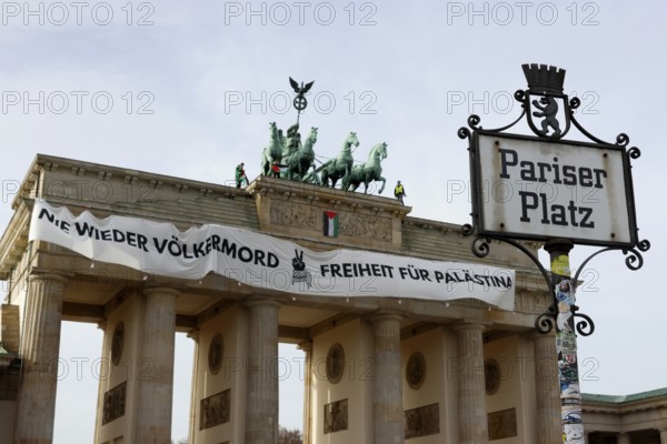 Several activists drop a banner with the inscription Never again genocide, freedom for Palestine