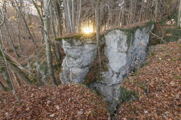 Low sun illuminates the rocks and caves of hell holes in the autumnal landscape of Dettingen an der
