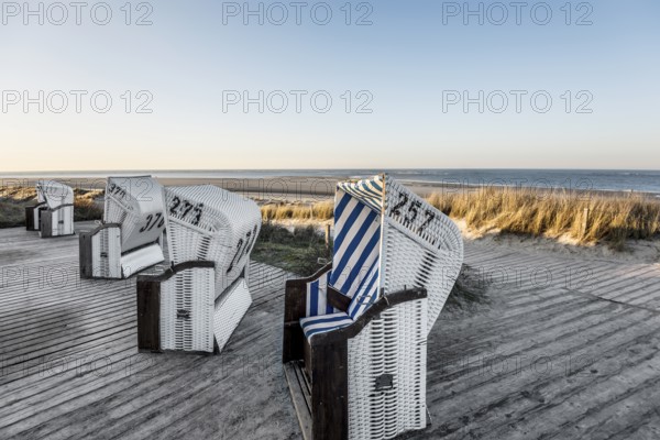 Beach chairs in the dunes and blue sky in winter, sunset, Spiekeroog, East Frisian Islands, Lower