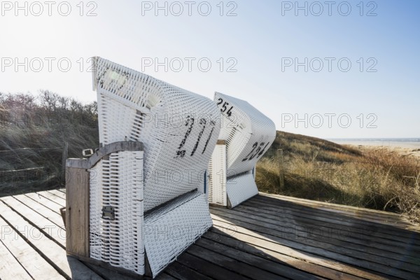 Beach chairs in the dunes and blue sky in winter, Spiekeroog, East Frisian Islands, Lower Saxony,