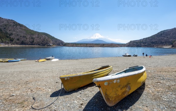 Rowing boats on shore, view across the lake to Mt Fuji volcano, Motosu Lake, Yamanashi Prefecture,
