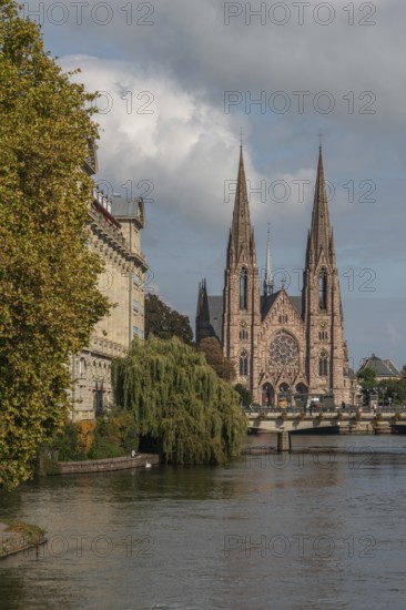 The two-towered church stands majestically on the banks of the river. Trees with golden leaves