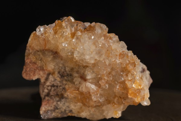 Quartz soil with sparkling crystals that are exposed on a grey surface. The lighting highlights the