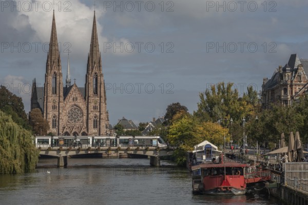 The two-towered church stands majestically on the banks of the river. Trees with golden leaves