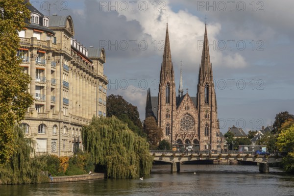 The two-towered church stands majestically on the banks of the river. Trees with golden leaves