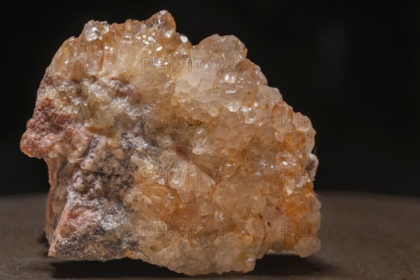This quartz crystal with its slight orange hue shimmers in the light. Well-defined facets can be