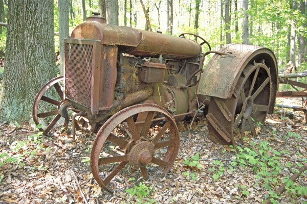 Rusted American Fordson tractor with iron tires around 1900, deposited in a wooded area, Marksboro,