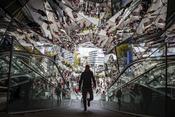 Young man on a stairway, entrance to a shopping center with many mirrors, Tokyu Plaza Omotesando