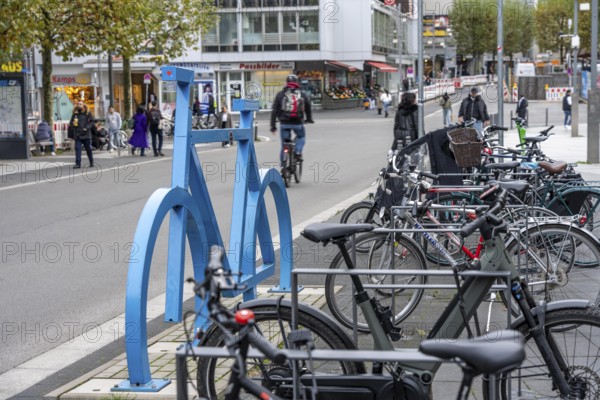 Bicycle parking spaces, with so-called leaning bars and a large blue bicycle silhouette, to make