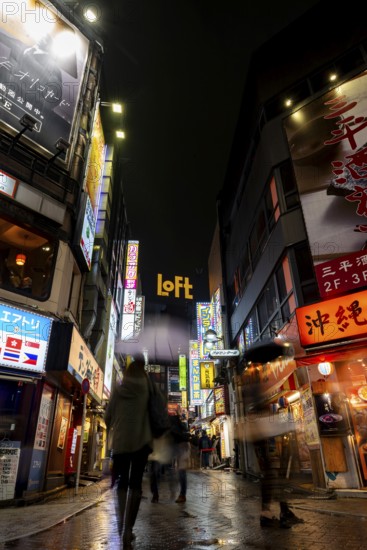 Busy pedestrian zone with many shopping centers and stores, illuminated with lots of neon signs at