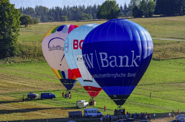 Hot air balloons are being prepared for takeoff as part of an air show at the Fliegerbergfest of