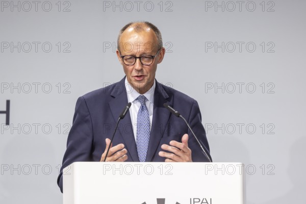 Federal Chancellor Friedrich Merz (CDU) . Portrait at the lectern with free text space.