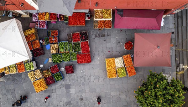 Traditional Mexican plaza with crates of peppers, onions, and tomatoes, economic prosperity in