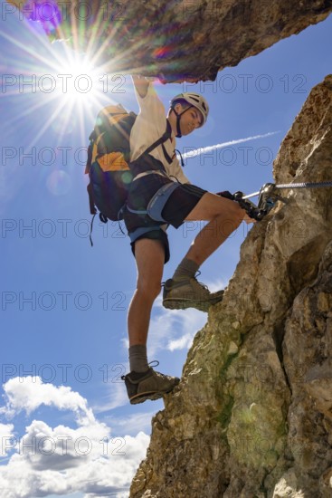 Mountaineer climbs on Ferrata Furcela de Saslonch, Langkofelscharte via ferrata, Dolomites,