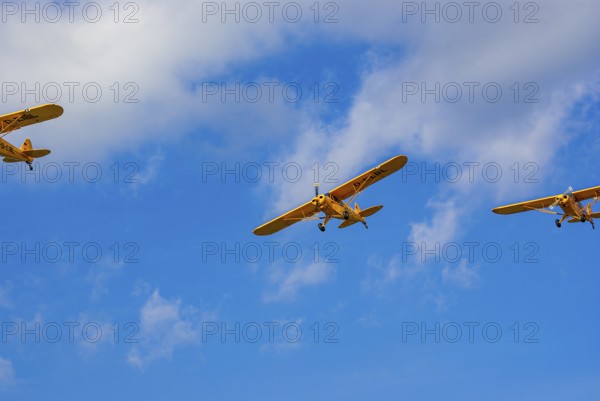 Three Piper PA-18 Super Cub aeroplanes of the Bravo Lima Formation flying in formation during an