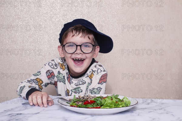 Child reacts dramatically to a salad served on a marble table at home during lunchtime, A little