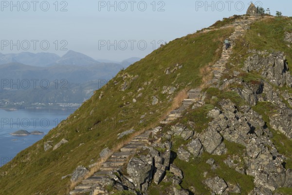 Woman with hiking poles walking up Rørsethornet stone stairs, with 3292 steps one of the longest