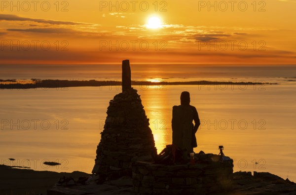Silhouette of a woman watching the sunset next to cairns, Rørsethornet stone staircase, with 3292