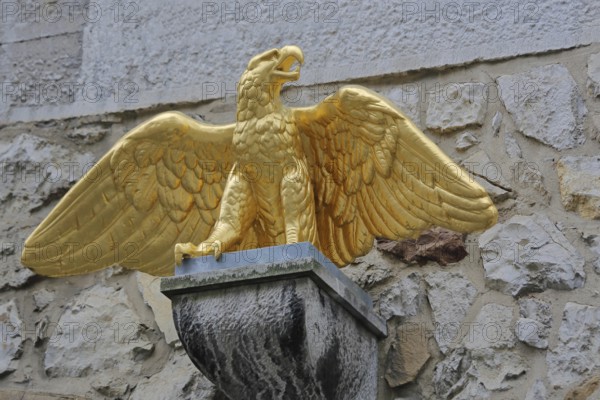Golden eagle figure with outstretched wings above the entrance to the Kupferhof Schleicher, gilded