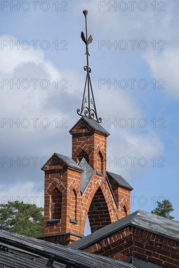 Iron ornamental element on roof peak, brick gable, former paper mill for the production of