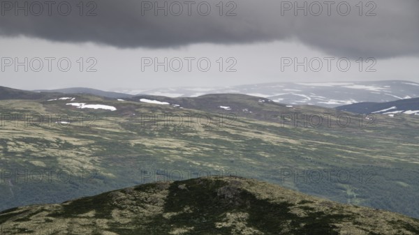 Vast mountain landscape with patches of snow and a cloudy atmosphere, pilgrimage route Olavsweg or