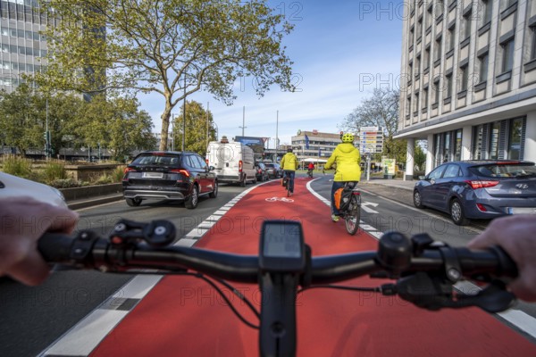 Riding a bike in a bike lane, marked in red to attract the attention of motorists, between 2 lanes,
