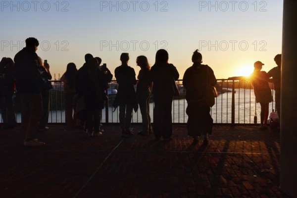 Crowd enjoying the view from the Elbphilharmonie over the Elbe at sunset, silhouettes, Plaza