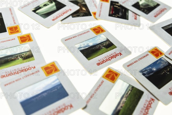 Many framed Kodachrome slides on a light table with magnifying glass, top shot