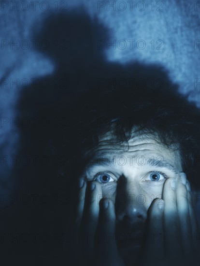A close-up of a man whose face is marked by fear, symbolising anxiety disorders, panic attacks,