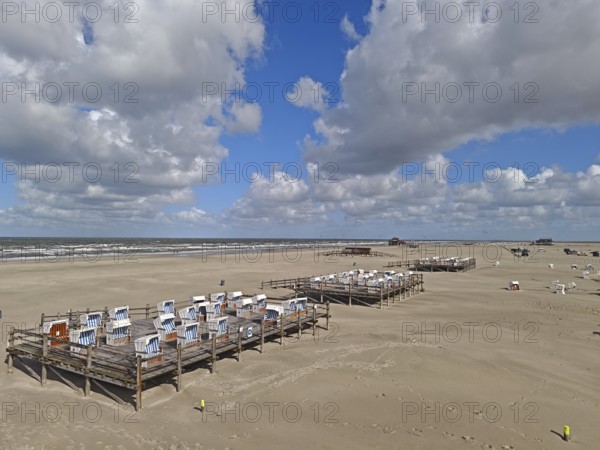 North Sea beach, blue sky, white clouds, summer, sun, sand, beach chairs on a platform, on the edge