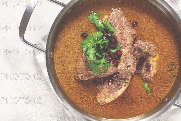 Fesenjan, an Iranian dish, stewed chicken, in a nut-pomegranate sauce, in a saucepan, light