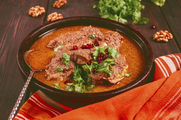 Fesenjan, an Iranian dish, stewed chicken, in walnut-pomegranate sauce, in an earthen pan,