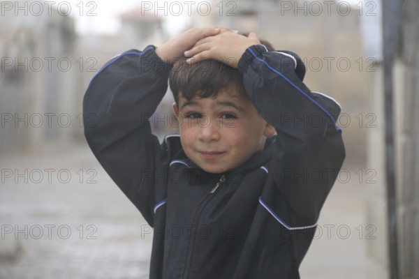 A Syrian refugee child photographed in a camp, reflecting the harsh living conditions of displaced