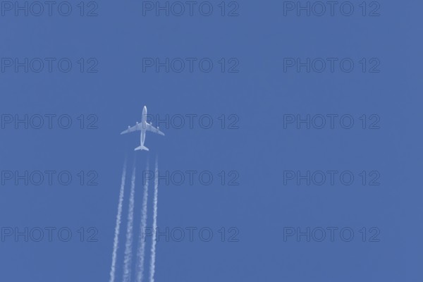 Airbus A340-300 jet aircraft of Lufthansa airlines in flight in a blue sky with vapour trails or