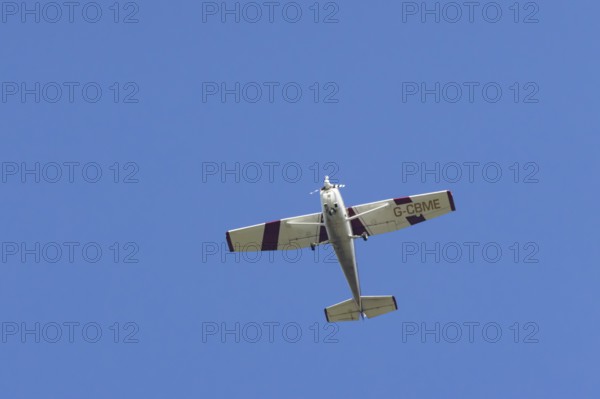 Reims Cessna F172M Skyhawk light aircraft flying in a blue sky, England, United Kingdom