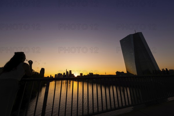 The sun sets behind the European Central Bank (ECB) and the Frankfurt banking skyline, Frankfurt am