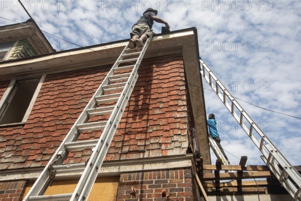 Detroit, Michigan - Workers re-roof a house they are remodeling in the Morningside neighborhood