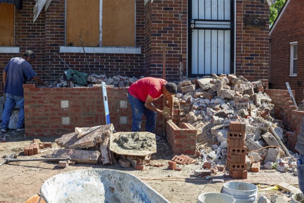 Detroit, Michigan - Workers rebuild the front porch of a house they are remodeling in the