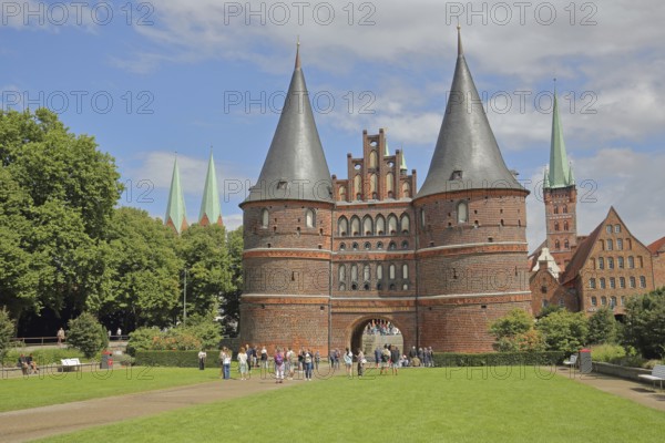 Historic Holsten Gate and pedestrians, tourists, St. Mary's Church, Lübeck St. Peter's Church