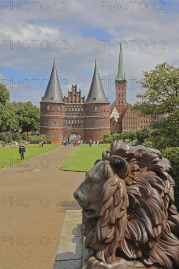 Lion figure at the historic Holstentor and St. Peter's church tower in Lübeck, Brick Gothic, Brick
