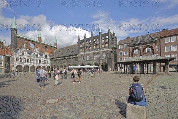 Renaissance and Gothic town hall and pedestrians, tourists, sitting and looking, looking at, Brick