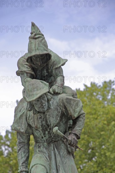 Sculpture Huckup monument by Carl Röder 1905, carrying figures on the back, modern art, bronze